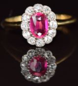 An 18ct gold ring set with an oval cut pink sapphire of approximately 0.7ct surrounded by