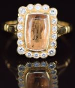 An 18ct gold ring set with a cushion cut imperial topaz of approximately 1.6ct surrounded by