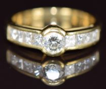 An 18ct gold ring set with a round cut diamond and eight princess cut diamonds, the largest