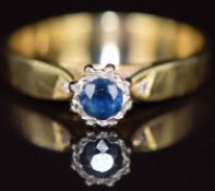 An 18k gold ring set with a round cut sapphire and two diamonds, 3g, size N