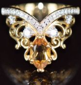 A 9k gold ring set with a marquise cut citrine of approximately 0.65ct and diamonds, the total