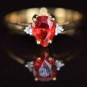 A 9k gold ring set with a pear cut Malawi ruby of approximately 0.78ct and two diamonds, 1.7g,