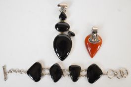 Two silver pendants and a silver bracelet, all set with agate