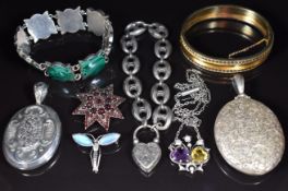 A collection of silver jewellery including two Victorian lockets with engraved scrolling decoration,
