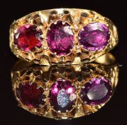 Victorian ring set with three foiled garnets, with scrolling decoration to the shoulders, size K,
