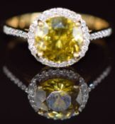 An 18k gold ring set with a round cut sphene of approximately 1.5ct surrounded by diamonds and