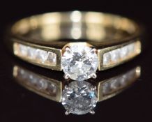 A 14k gold ring set with a round cut diamond of approximately 0.46ct and with further diamonds to