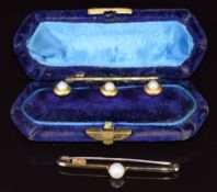 A set of three yellow metal studs each set with a split pearl (3g) in original box and a 14k gold