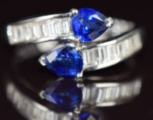 An 18k white gold ring set with two pear cut sapphires, each approximately 0.5ct and baguette cut