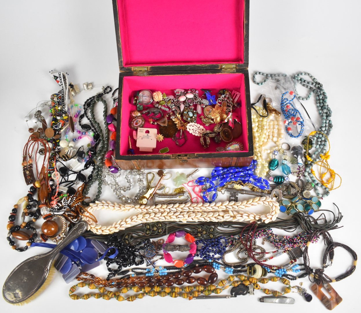 A collection of jewellery including beaded necklaces, filigree brooch, silver backed brush, Siam