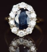 An 18ct gold ring set with an oval cut sapphire of approximately 2.4ct surrounded by ten round cut