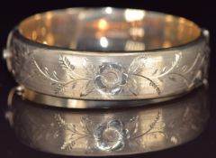 A 9ct gold bangle with engraved floral decoration, 20.2g, 6 x 5.4cm