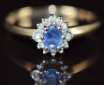 A 9ct gold ring set with an oval cut sapphire surrounded by diamonds, 2.1g, size S