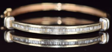 A 14ct gold bangle set with baguette cut diamonds, 16.2g, 5.8 x 5.2cm