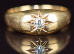 An 18ct gold ring set with an old cut diamond of approximately 0.12ct in a star setting,