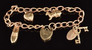 A 9ct gold charm bracelet with four 9ct gold charms comprising a rabbit, shoe, heart and keys 12.3g,