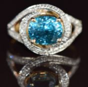 A 9k gold ring set with an oval cut Ratanakiri zircon of approximately 5.1ct surrounded by diamonds,