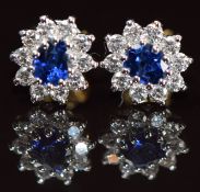 A pair of 18ct gold earrings each set with an oval cut sapphire of approximately 0.25ct surrounded