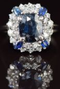 An 18ct gold ring set with an oval cut sapphire of approximately 1.6ct surrounded by sapphires and