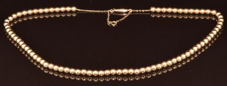 Edwardian 15ct gold necklace made up of spherical links threaded on a chain with barrel clasp, 24.