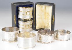 Six various hallmarked silver napkin rings including a cased pair with engine turned decoration,