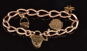 A 9ct rose gold bracelet made up of oval twisted links with two 9ct gold charms and a yellow metal