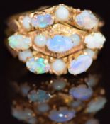 A 9ct gold ring made up of three bands, each set with opals, 4.2g, size L