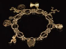 A 9ct gold charm bracelet with nine 9ct gold charms including New Zealand, Australia, pixie, etc,