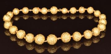 Victorian yellow metal necklace made up of embossed floral spherical beads, the largest 16.2mm and