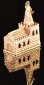 A 9ct gold charm in the form of a church opening to reveal a wedding ceremony, 6.3g