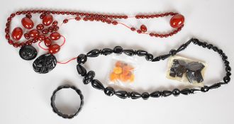 A collection of cherry amber beads (81g), Baltic amber beads, two jet brooches, jet bracelet and jet