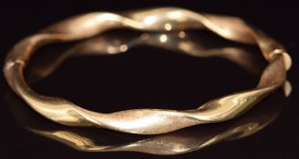 An 18ct gold bangle in a twist design with brushed finish, 8.9g, 5.9 x 5.2cm