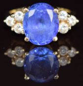 An 18ct gold ring set with an oval cut tanzanite of approximately 5ct and three round cut diamonds