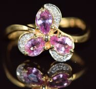 An 18k gold ring set with three pear cut Padparadcha sapphires totalling approximately 1.05ct and