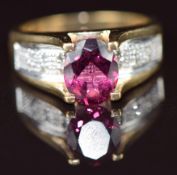 A 9k gold ring set with an oval cut garnet and diamonds, 5.7g, size N