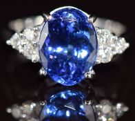 An 18k white gold ring set with an oval cut tanzanite of approximately 3ct and three diamonds to
