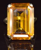 A 9ct gold ring set with an emerald cut synthetic yellow sapphire of approximately 30ct, 11.3g, size
