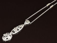 An 18k white gold necklace set with round cut diamonds in a pierced floral design, 10.8g, 44cm