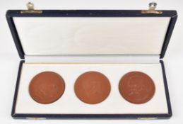 Cased set of three East German Meissen porcelain medallions depicting Engels, Marx and Lenin, each