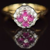 An 18ct gold ring set with four rubies surrounded by diamonds, 3.8g, size N