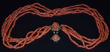 A c1900 five strand coral necklace made up of faceted beads, the gold clasp set with a carved