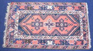 A pink ground rug with geometric border, 208 x 117cm