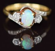 An 18ct gold ring set with an opal cabochon and diamonds in a platinum setting, 4g, size M