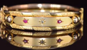 Edwardian 9ct gold bangle set with an old cut diamond and two pear cut rubies, 14.3g, 6.3 x 5cm