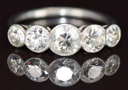 A platinum ring set with five round cut diamonds, the centre diamond approximately 0.6ct, total