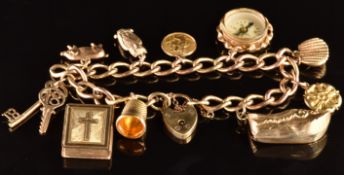 A 9ct gold charm bracelet with ten 9ct gold charms including Bible, clog, compass, pig, owl and St