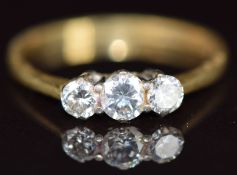 An 18ct gold ring set with three diamonds, the centre diamond approximately 0.2ct, 2g, size K