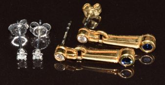 A pair of 9k white gold earrings each set with a diamond (0.4g) and a pair of 18k gold earrings each