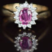 A 9k gold ring set with an oval cut pink sapphire of approximately 0.6ct surrounded by diamonds, 2.