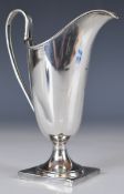 George V hallmarked silver jug in the Georgian style, raised on a square base, London 1934, maker